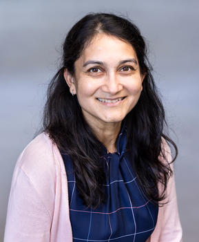 A headshot of Smriti Kansal, ECE advisor, wearing a pink cardigan and navy-blue blouse.