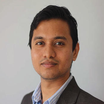 Sai Manoj wears a dark blazer and striped-blue shirt in his profile for the Mason news story.