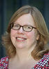 Mason associate professor Jill Nelson wears a red, checkered shirt and glasses in her faculty profile